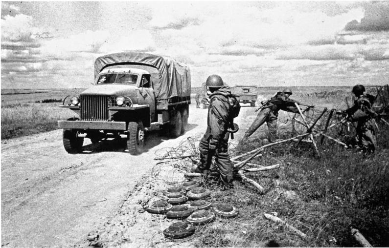 Советские саперы расчищают дорогу от мин и проволочных заграждений. По дороге едет грузовик Студебеккер (Studabaker US-6)
