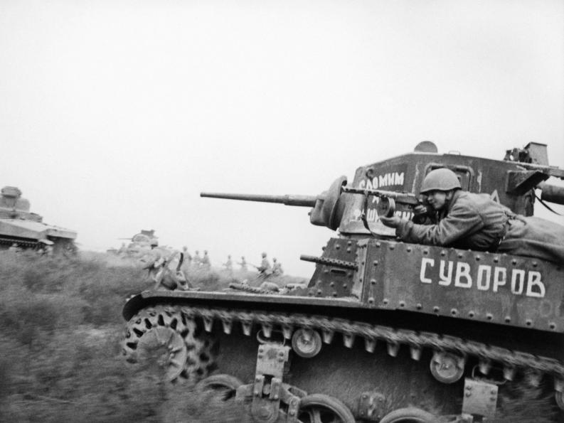 Пехотинец прицеливается из пистолета-пулемета, лежа на броне советского танка американского производства М3 «Стюарт» с именем собственным «Суворов». Донской фронт