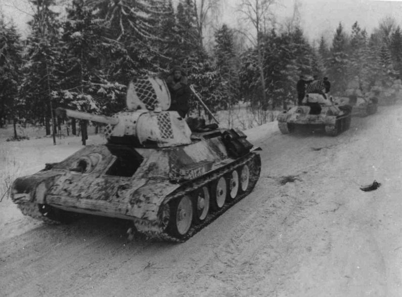 Колонна Т-34 1-й гвардейской танковой бригады в зимнем камуфляже на марше. 1942