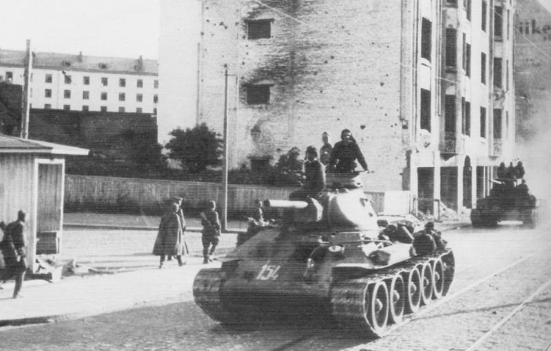 Советский танк Т-34 на марше по улице освобожденного города Выборга. Июль 1944