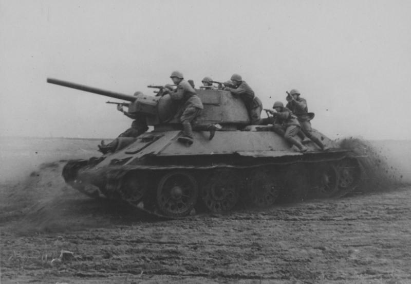 Советский танк Т-34 с танковым десантом во время атаки. 1944