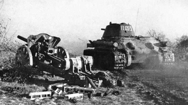 Советский танк Т-34-76 проезжает мимо брошенной немецкой гаубицы 10,5 cm leFH 18