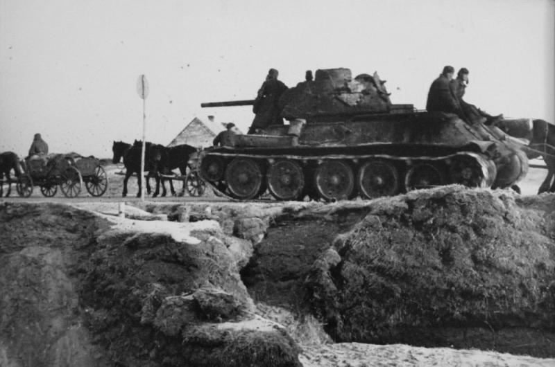 Танк Т-34 9-го гвардейского танкового корпуса и обоз на дороге в Польше. Март – апрель 1945