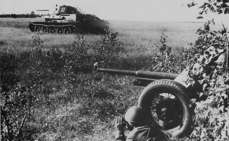 Танк Т-34 образца 1941 г. из 101-й танковой дивизии идет в атаку при поддержке 45-мм противотанковой пушки 53-К. Западный фронт. Июль 1941