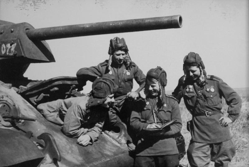 Четверо советских танкистов-гвардейцев у танка Т-34. Весна 1944